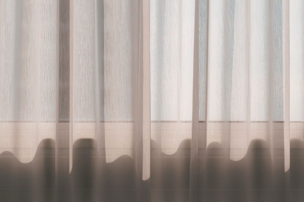 Geschlossene leicht transparente Vorhänge als Symbol für guten Schlaf in der Perimenopause und Menopause.