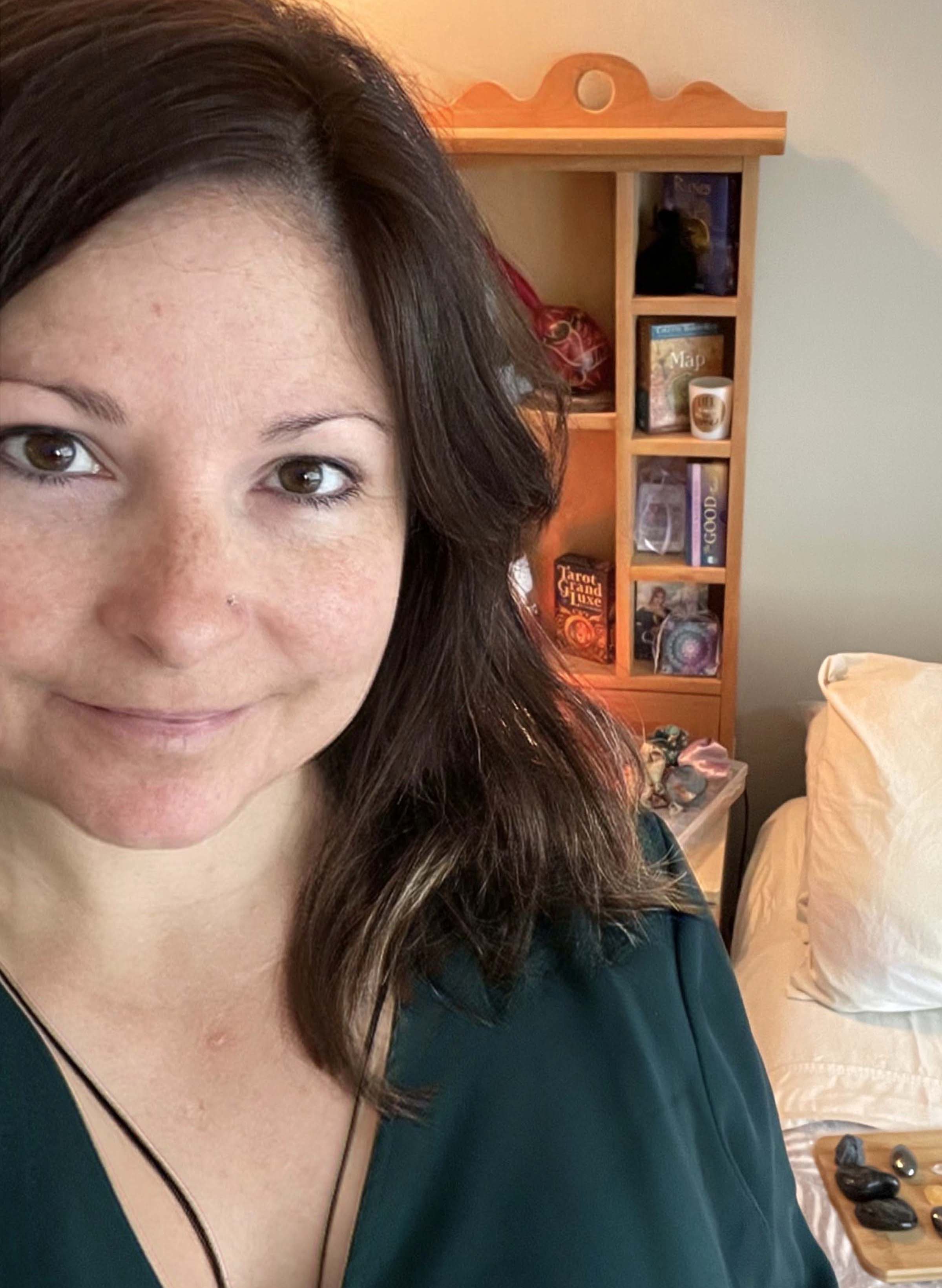 Lana, Certified Crystal and Reiki Practioner, SharQui Bellydance Instructor, and Sistership Circle Facilitator of Winnipeg, MB,  stands in front of a Chakra Flag and smiles with welcome