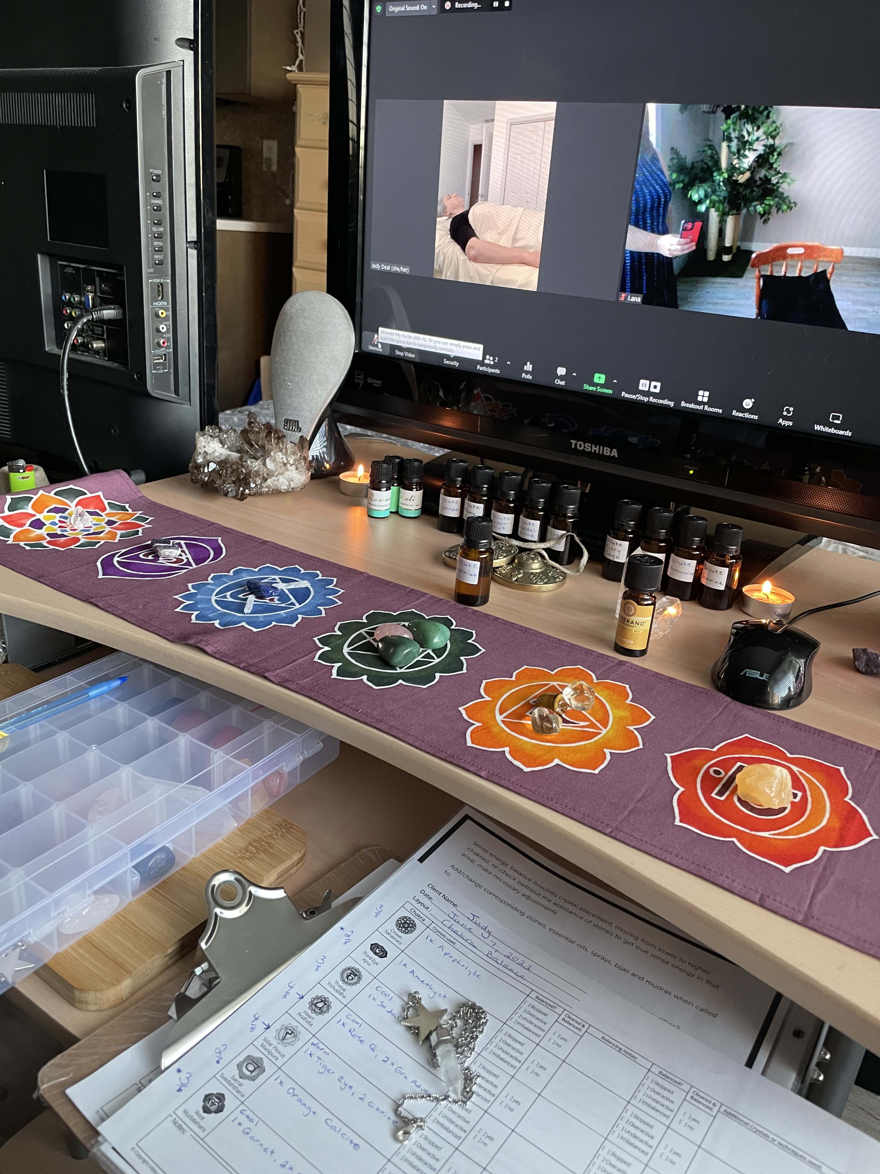 Lana, Certified Crystal and Reiki Practioner, SharQui Bellydance Instructor, and Sistership Circle Facilitator of Winnipeg, MB,  stands in front of a Chakra Flag and smiles with welcome