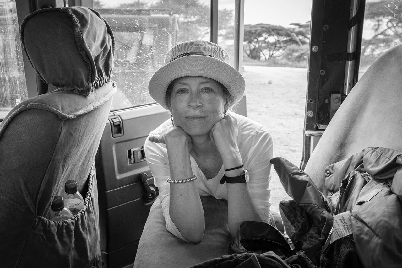 black and white photo of woman in hat leaning into car