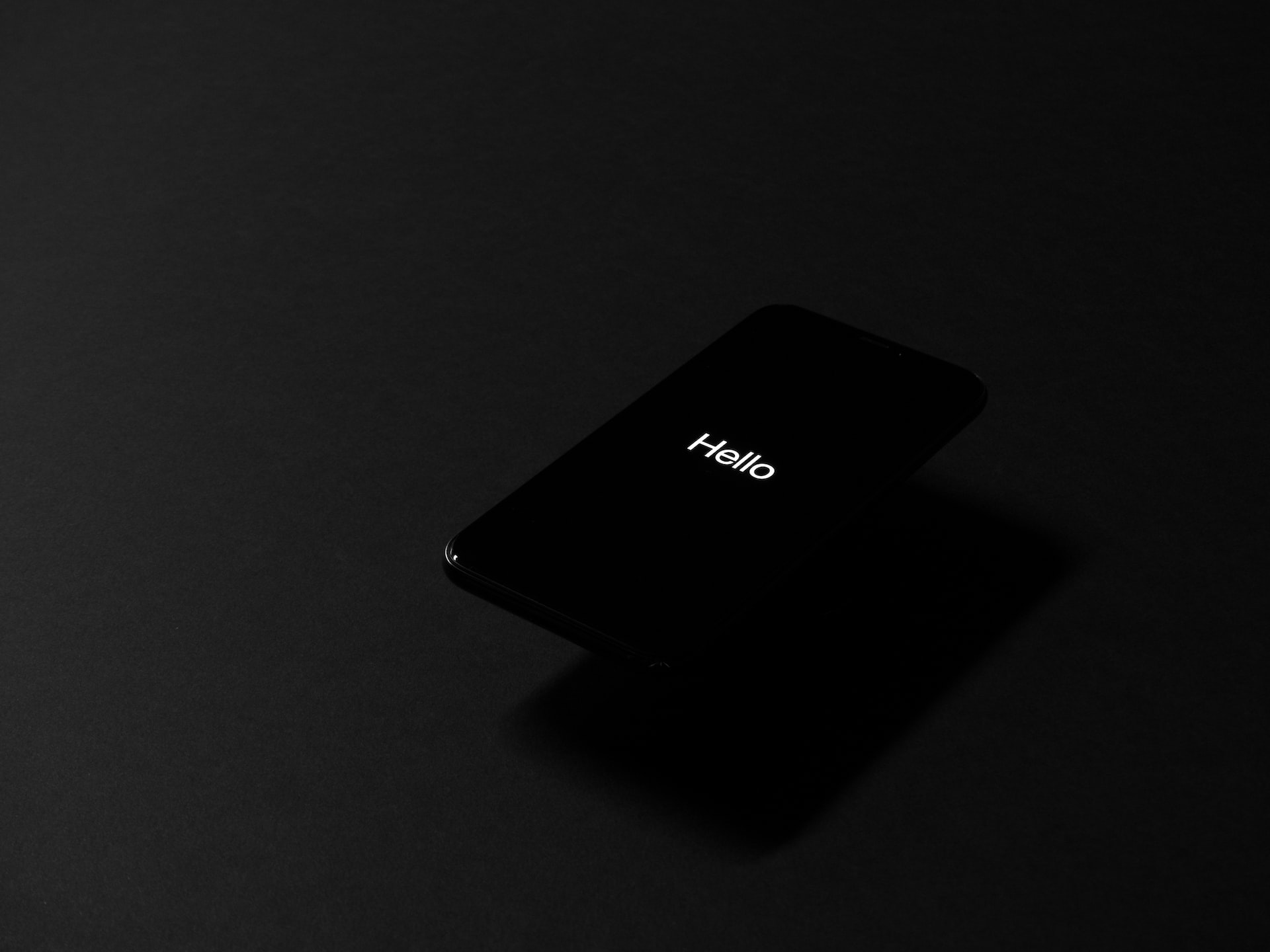 A smartphone with the word Hello on the screen on a dark background